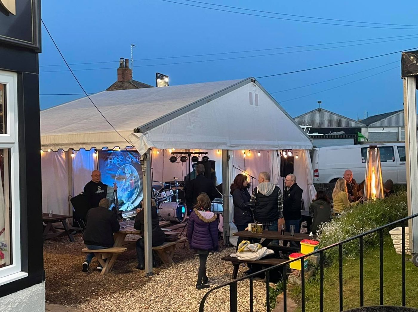 A live band playing in the garden marquee at dusk